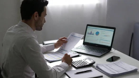 New business owner reviewing line of credit options and financial documents at a desk