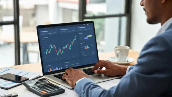 Business owner reviewing fluctuating monthly revenue on a laptop