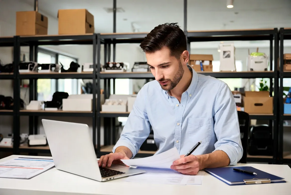 Business owner planning loan options with equipment and inventory nearby