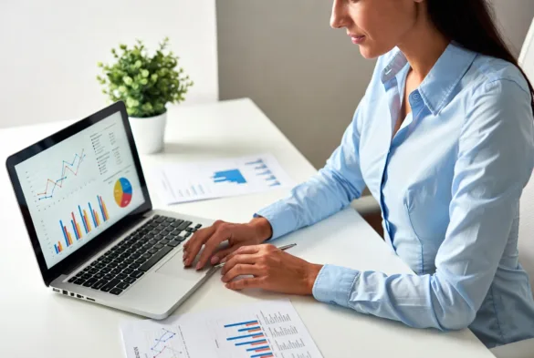 Small business owner reviewing financing options on laptop with documents